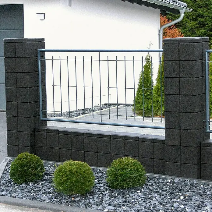 Christoph Gartenmauer Ambienta - 40 x 20 x 20 cm, Anthrazit, Beton - Das Bild zeigt einen Zaun aus Betonblöcken mit Metallgitter und kleinen grünen Büschen. Ideal zur Dekoration und als Grundstückseingrenzung.