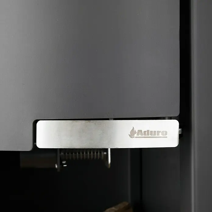 Aduro Kaminofen 1-4 - 6 kW, Raumheizvermögen: 334 m³, Material Verkleidung: Stahl, Schwarz - Nahaufnahme eines Aduro-Holzofens mit silbernem Bedienfeld und Logo, das die Marke und das Design des Produkts hervorhebt.