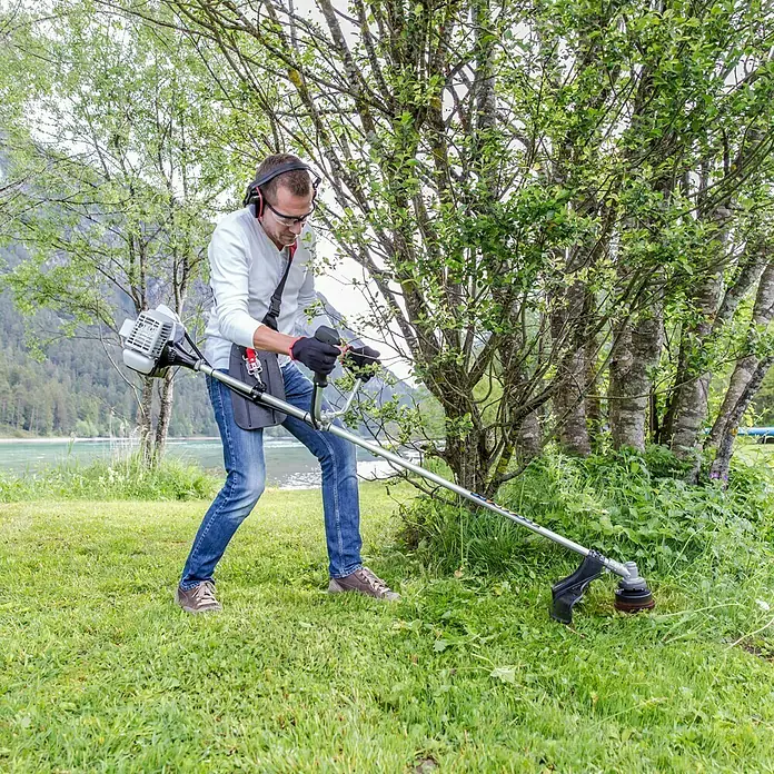AL-KO Benzin-Motorsense BC 223 B - 700 W, Schnittbreite Faden: 41 cm, Schnittbreite Messer: 25 cm - Ein Mann, der eine Motorsense benutzt, um Gras zu schneiden, mit Sicherheitsausrüstung.