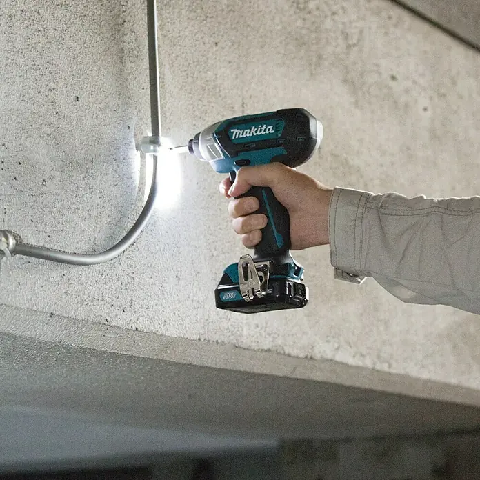 Makita Llave de impacto de batería TD110DSMJ - 10,8 V, 2 baterías, 4 Ah - Atornillador de impacto inalámbrico Makita en uso, ideal para tareas de montaje. La herramienta ofrece alto rendimiento.