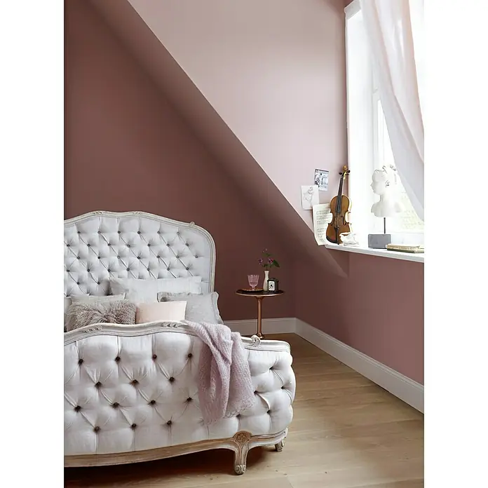 Alpina Wandfarbe Feine Farben - Melodie der Anmut, Matt, 2,5 l, Konservierungsmittelfrei - Elegantes Schlafzimmer mit weißem Polsterbett und rosa Wand, die eine warme und einladende Atmosphäre schafft. Ein Violinen-Dekor verleiht dem Raum musikalische Note.