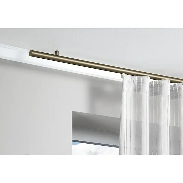 Expo Ambiente Deckenträger - Bronziert, Geeignet für: Ø 16, Ø 20, Ø 25, 18 x 18 mm Profile - Eine deckenmontierte Gardinenstange aus Messing mit weißen Vorhängen, die eine elegante und funktionale Fensterdekoration bietet.