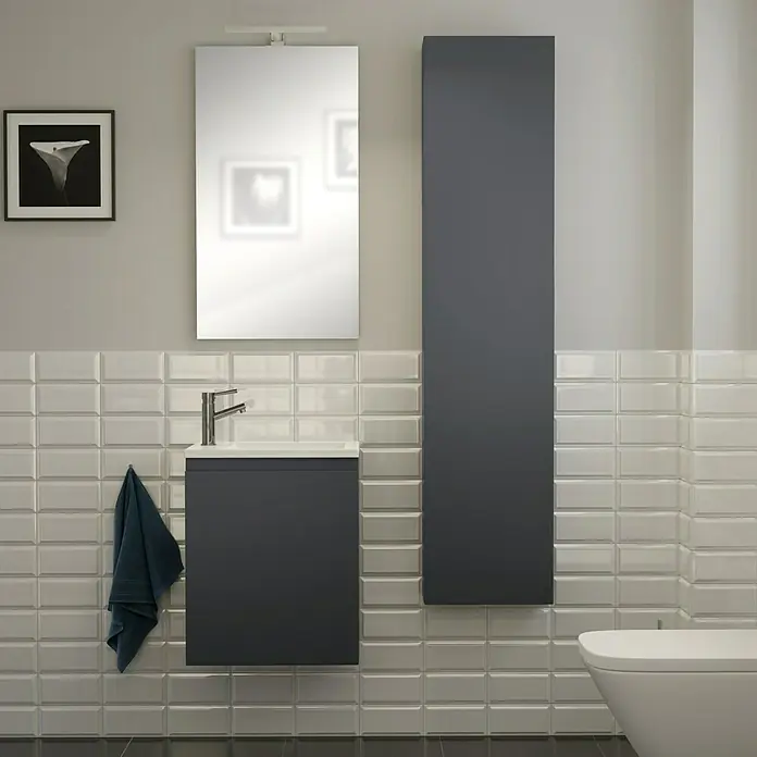 Camargue Espacio Badmöbel-Set H44 - 90 cm, Gama anthrazit matt - Elegantes Badezimmer-Interieur mit einem grauen Waschtischunterschrank, einem hochformatigen Schrank und einem Spiegel, ergänzt durch stilvolle Fliesen und dunkle Bodenfliesen.