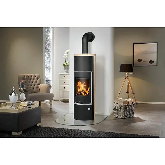Justus Kaminofen Faro Aqua 2.0 - 8,5 kW, Raumheizvermögen: 200 m³, Material Verkleidung: Sandstein, Sandstein/Schwarz - Elegantes Wohnzimmer mit einem stilvollen schwarzen Kaminofen mit Holzablage und passender Einrichtung für gemütliche Stunden.