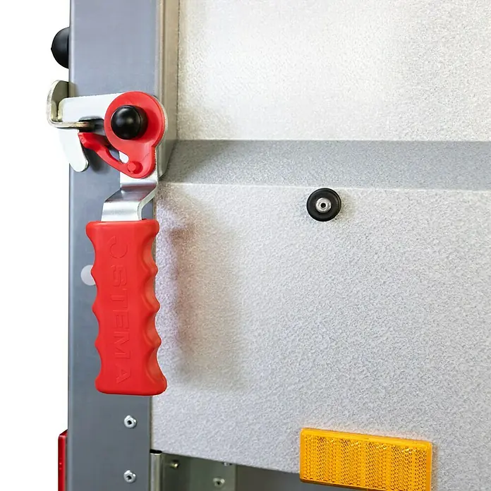Stema Anhänger BH-R 550 - Nutzlast: 455 kg, Einachser, Kasteninnenmaß: 154 x 108 x 33 cm, Ungebremst - Detailansicht eines Anhängers mit rotem Griff und gelbem Reflektor. Der robuste Verschlussmechanismus sorgt für Sicherheit beim Transport.