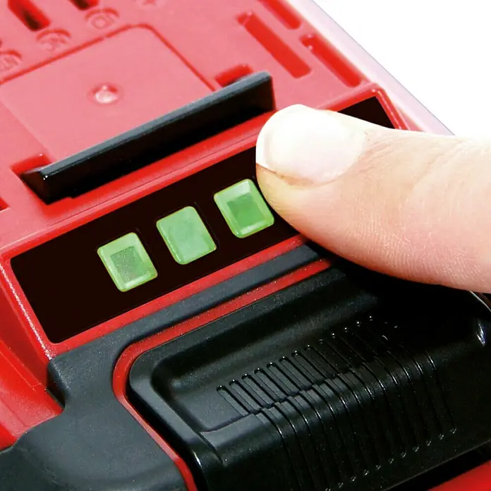Einhell Power X-Change 18V Akku Power X-Change Plus - 18 V, 5,2 Ah - Finger drückt Batteriestandsanzeige mit drei grünen LED-Leuchten, Teil einer roten Batterie.