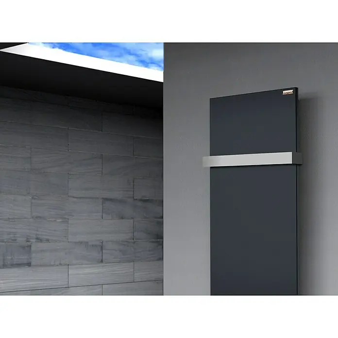 Szagato Designheizkörper Manhattan 2 - B x H: 470 x 1.200 mm, Wärmeleistung bei Vorlauftemperatur von 75 °C (D: 50): 799 W, Anthrazit, Mit 1 Handtuchhalter (50 mm) - Ein moderner, schwarzer Handtuchwärmer mit einer eleganten, silbernen Halterung an einer grauen Wand. Er sorgt für warme Handtücher und ein stilvolles Badezimmer.