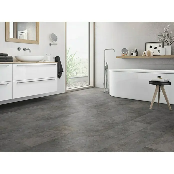 Classen Vinylbodenmuster GreenVinyl Nimbus Dark - 300 x 310 x 4 mm, Fliesenoptik - Ein modernes Badezimmer mit grauen Bodenfliesen, einem weißen Waschtisch und einer freistehenden Badewanne für entspannende Momente.