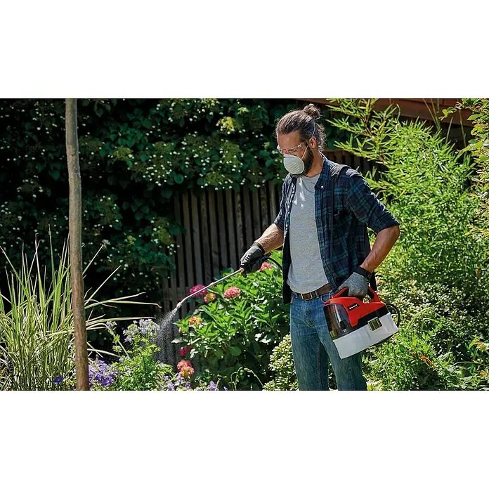 Einhell Power X-Change 18V Akku-Sprühgerät GE-WS 18/35 Li-Solo - 18 V, Anzahl Akkus: Ohne Akku, Betriebsdruck: 2,5 bar - Mann im Garten, der mit einem Einhell Akku-Drucksprüher Pflanzen besprüht, geschützt mit Maske und Brille.