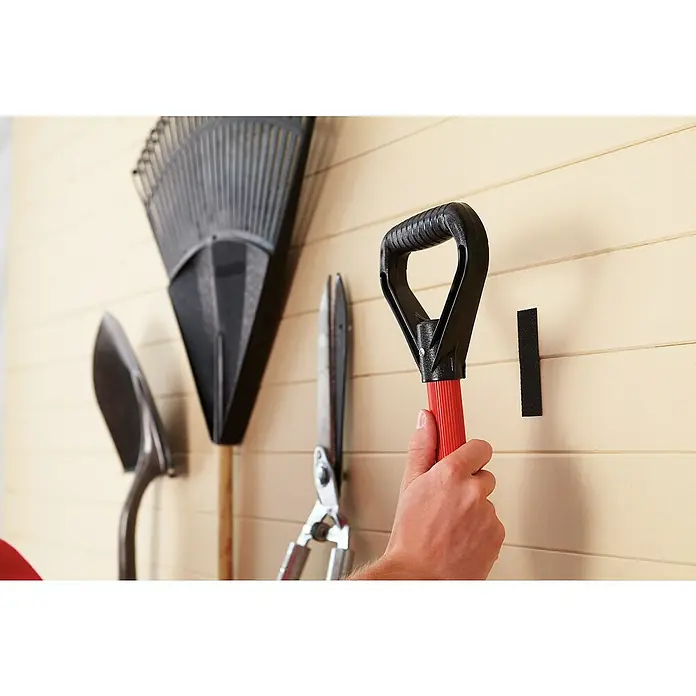 3M Scotch Cinta engomada Extreme - 25 mm x 1 m, Negro - Primer plano de herramientas colgadas en una pared, como una pala, un rastrillo y unas tijeras. Una mano alcanza una herramienta.