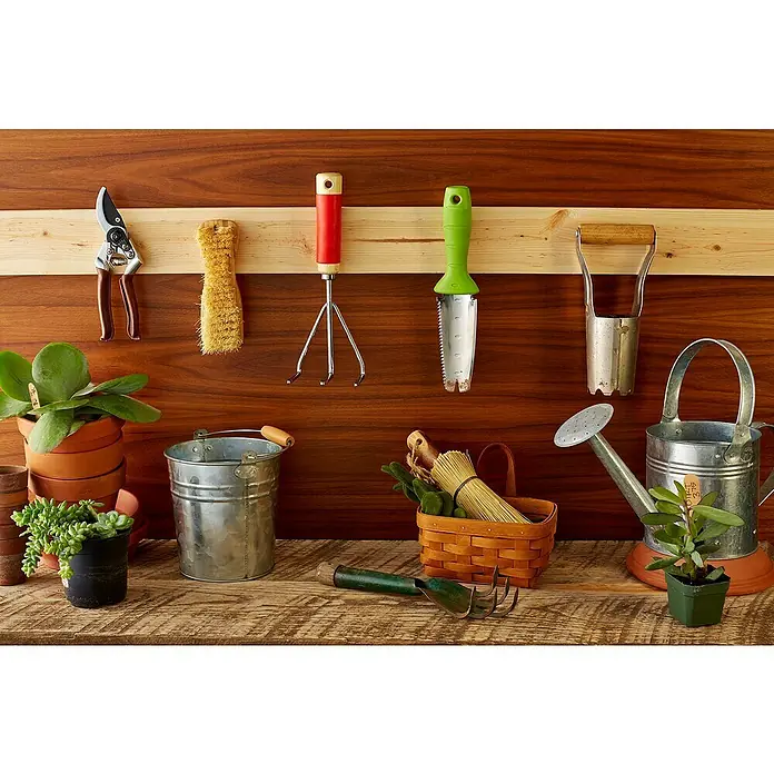 3M Scotch Cinta engomada Extreme - 25 x 76 mm, Negro - Varias herramientas de jardinería, plantas en macetas, una regadera y un cubo se exhiben en un estante de madera.
