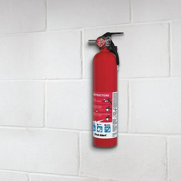 3M Scotch Cinta engomada Extreme - 25 mm x 1 m, Blanco - Extintor rojo First Alert montado en una pared blanca, garantizando la seguridad en caso de emergencia.