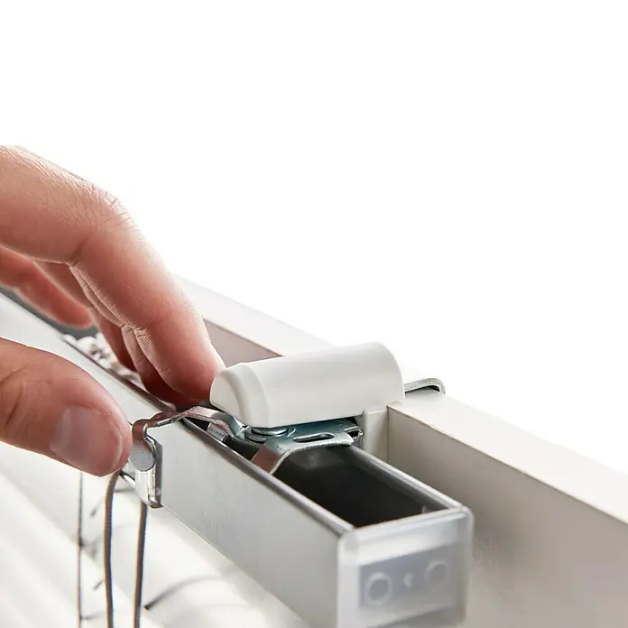 Expo Ambiente Klemmträger - 2 Stk., Geeignet für: Alu-Jalousien, Weiß - Detailaufnahme einer Jalousieaufhängung mit Hand, die das System bedient. Fokus liegt auf der Funktionalität und dem Design der Jalousie.