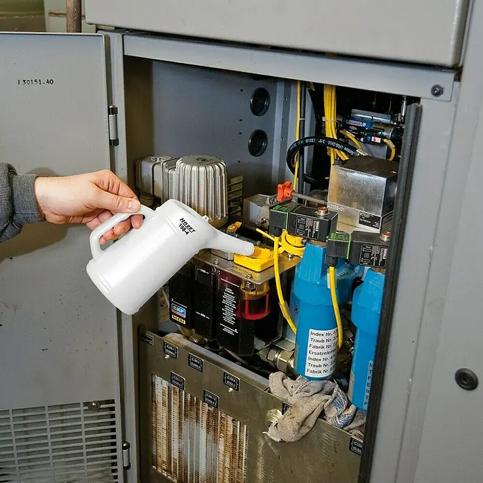 Hazet Messbecher 198-4 - 1 l - Eine HAZET 198-4 Gießkanne wird verwendet, um Öl in eine industrielle Maschine zu füllen. Präzise und sauber!