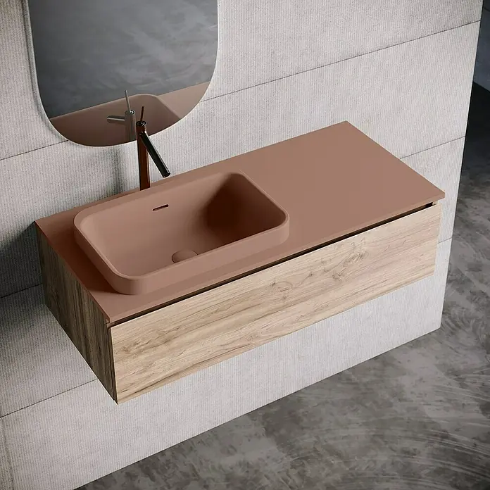 Lavabo y encimera Paul izquierda - 46 x 101 cm, Orificios para grifo: Izquierda, Con desbordamiento, Rosa california - Elegante lavabo de baño con una encimera marrón claro y un armario de madera debajo. Un espejo ovalado cuelga sobre el lavabo.