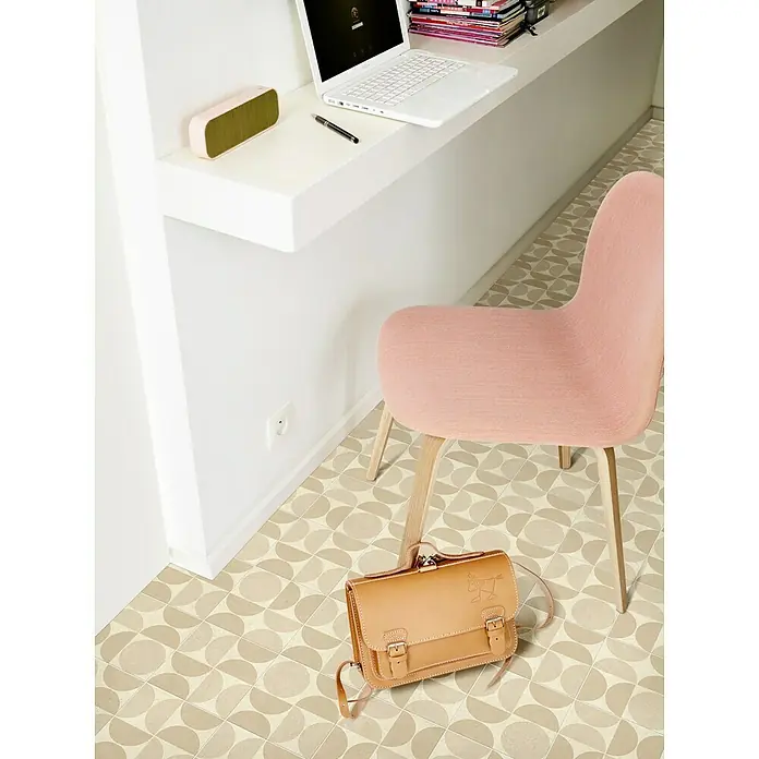 Beauflor PVC-Boden Meterware Calypso - 400 cm, Beige - Eine beigefarbene Ledertasche mit Schnallenverschluss liegt unter einem rosa Stuhl auf einem Boden mit Halbkreis-Muster.