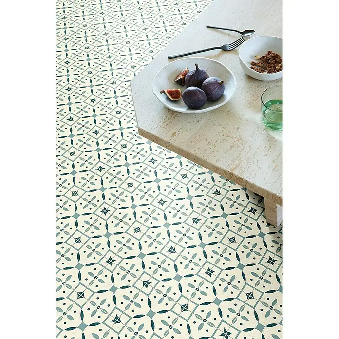 Beauflor PVC-Boden Meterware Calypso - Sonstige, Breite: 400 cm, Hellgrün/Beige - Das Bild zeigt einen Boden mit einem dekorativen, blauen Fliesenmuster und einem Tisch mit Feigen, Müsli und einem Glas Wasser.