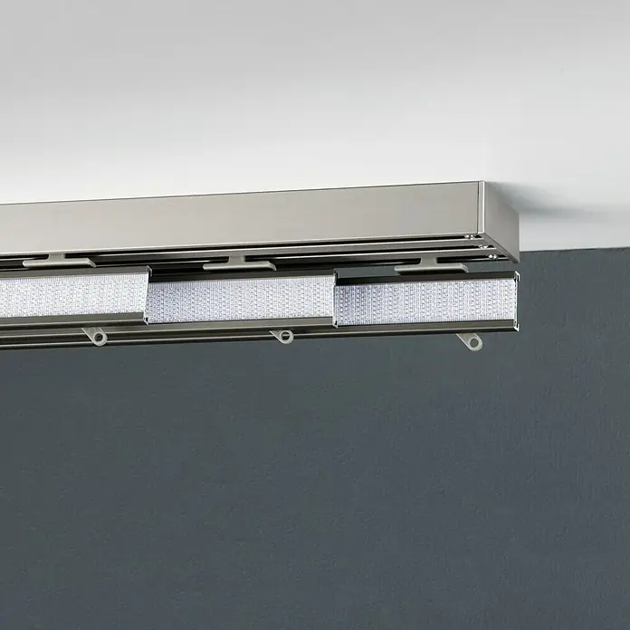 Expo Ambiente Gardinenprofil Smart Set - Anzahl Läufe: 3 Stk., Silber, 160 cm - Nahaufnahme einer eleganten, modernen Lamellen-Vorhangschiene in Silber, befestigt an einer Decke, mit Stoffbahnen.