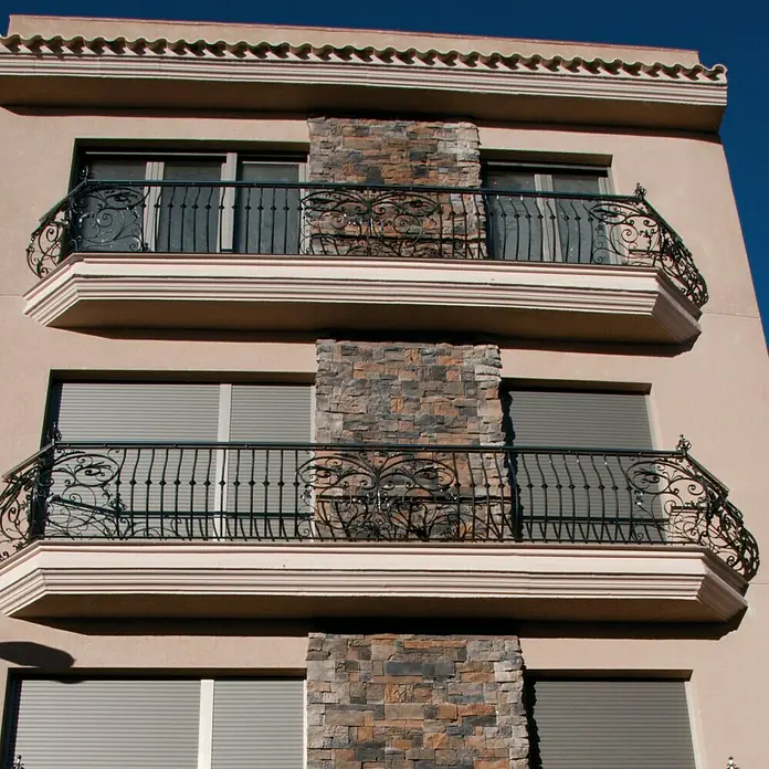 Revestimiento de piedra Montblanc Otoño - Cantidad total: 4 pzs. - Fachada de un edificio con balcones de hierro forjado y persianas que ofrecen un diseño elegante y seguro.