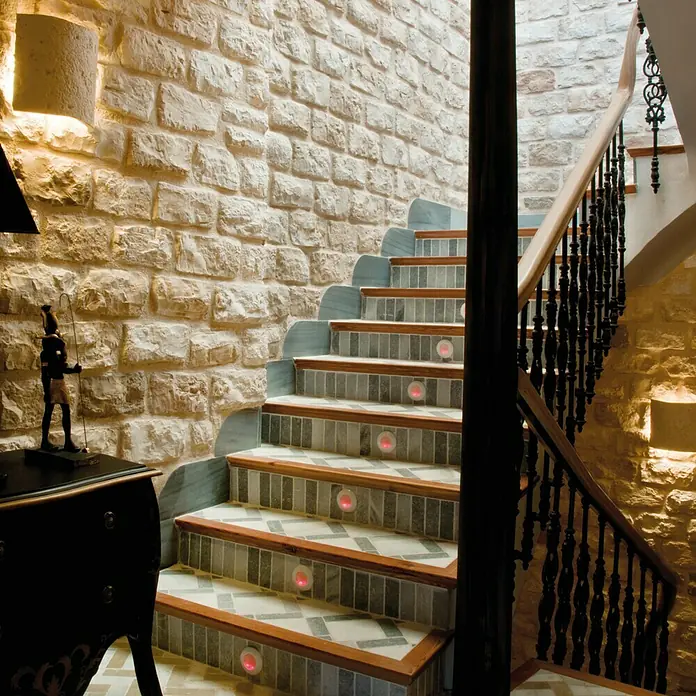 Revestimiento de piedra Silleria Cobre - Cobre, Cantidad total: 4 pzs. - Elegante escalera con iluminación integrada y pared de piedra. Las luces empotradas destacan los escalones con estilo.