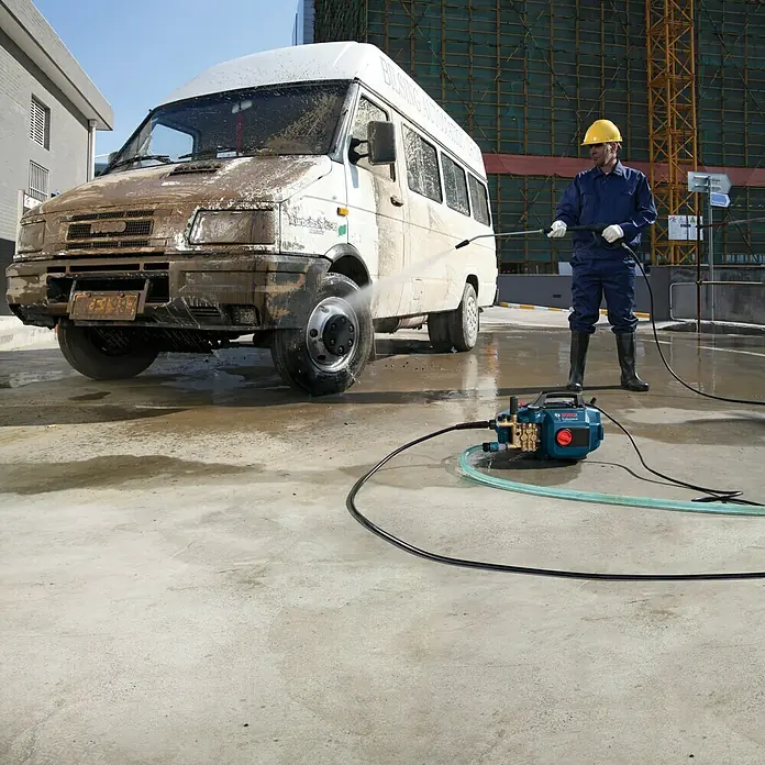 Bosch Professional Hochdruckreiniger GHP 5-13 C - 130 bar, 2.300 W, Fördermenge: 520 l/h - Ein Arbeiter reinigt mit einem Bosch Hochdruckreiniger einen verschmutzten Lieferwagen auf einer Baustelle.