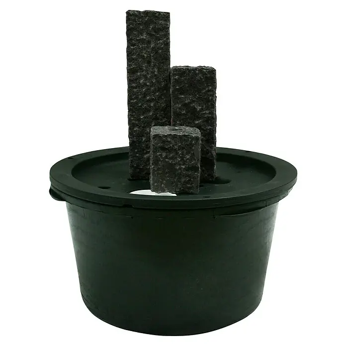 Ubbink AcquaArte Einbaubrunnen Taranto - Naturmaterialien, Dunkelgrau - Ein Zimmerbrunnen mit drei dunklen Steinsäulen in einem schwarzen Behälter. Das Produkt ist ein dekorativer Brunnen für Innenräume.
