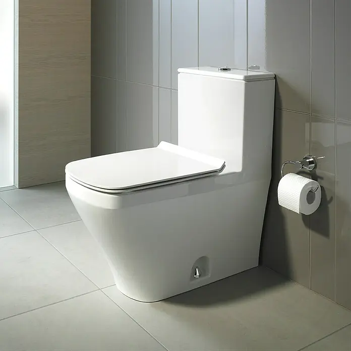 Duravit DuraStyle Spülkasten - Ohne Spezialglasur, Links, Keramik, Weiß - Nahaufnahme einer modernen, weißen Toilette in einem Badezimmer mit grauen Fliesen und einem Toilettenpapierhalter an der Wand.