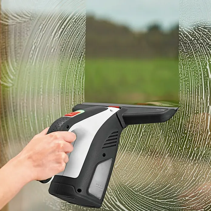 Bosch Akku-Fenstersauger GlassVac Set - 3,6 V, 2 Ah - Fensterreiniger im Einsatz, um eine Fensterscheibe streifenfrei zu säubern. Das Gerät liegt gut in der Hand für eine einfache Bedienung.
