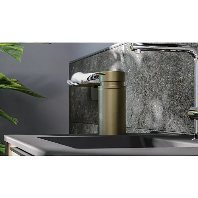 Camargue Antwerpen Seifenspender - Edelstahl, Gold - Eine moderne Badezimmerarmatur mit einem goldenen Seifenspender und einem silbernen Wasserhahn vor einer dunklen, texturierten Wand.
