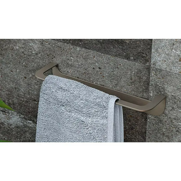 Camargue Antwerpen Handtuchhalter - Breite: 32 cm, Graphit, Matt - Ein modernes, bronzefarbenes Handtuchhalter-Design mit einem grauen Handtuch an einer strukturierten Wand.