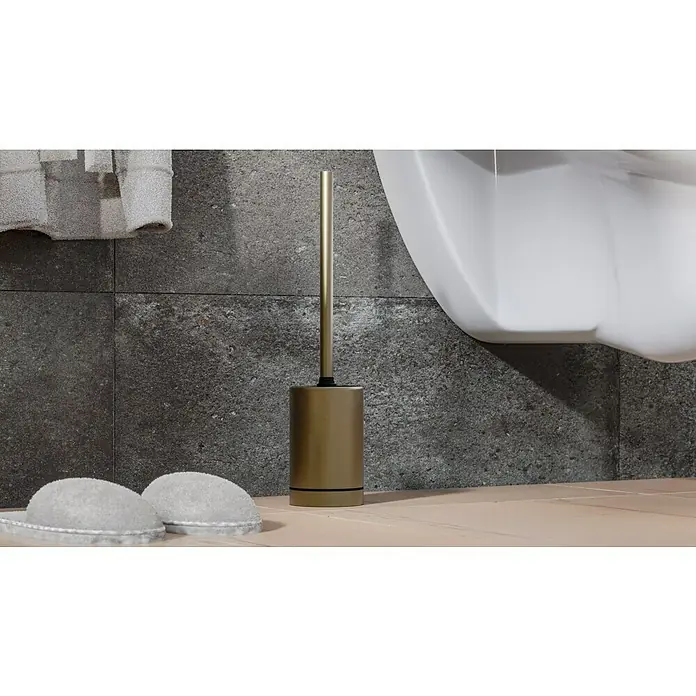 Camargue Antwerpen WC-Bürstengarnitur - Edelstahl, Gold - Eine goldfarbene Toilettenbürste mit Halter steht neben einer Toilette und Hausschuhen im Badezimmer. Praktisches Badaccessoire.