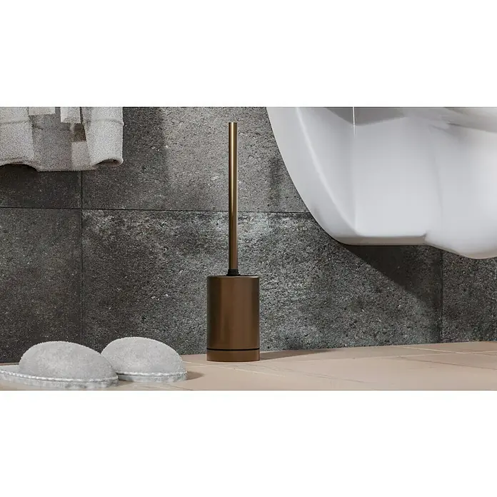 Camargue Antwerpen WC-Bürstengarnitur - Edelstahl, Kupfer - Elegante bronzefarbene Toilettenbürste mit Halter neben einer Toilette und Hausschuhen. Das Badezimmer ist modern gestaltet.