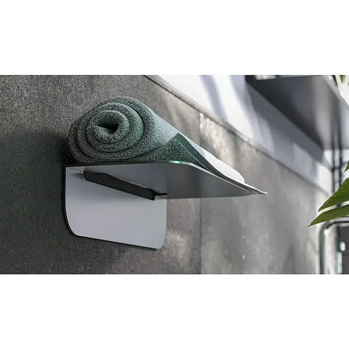 Camargue Antwerpen Ablage - Breite: 25 cm, Edelstahl, Matt - Ein aufgerolltes grünes Handtuch liegt auf einem modernen silbernen Wandregal vor einer grauen Wand. Schlichtes und funktionales Design.