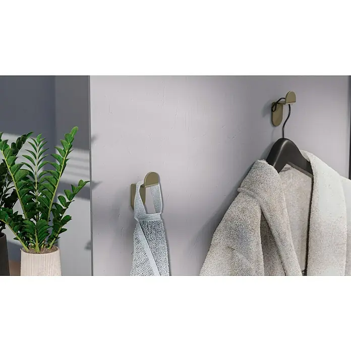Camargue Antwerpen Handtuchhaken - 2 Stk., Gold, Matt - Ein weicher, weißer Bademantel hängt an einem eleganten, schwarzen Kleiderbügel an der Wand. Ein graues Handtuch hängt an einem Haken daneben.