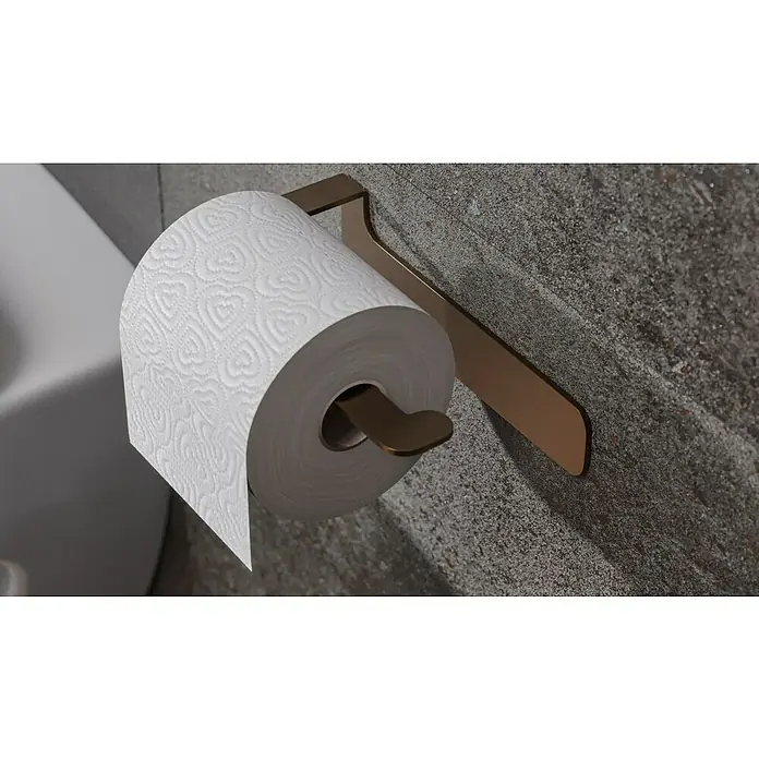 Camargue Antwerpen Papierrollenhalter - 16,5 x 9 x 5,5 cm, Kupfer, Matt - Nahaufnahme einer Toilettenpapierrolle mit Herzmuster auf einem bronzefarbenen Halter an einer grauen Wand.