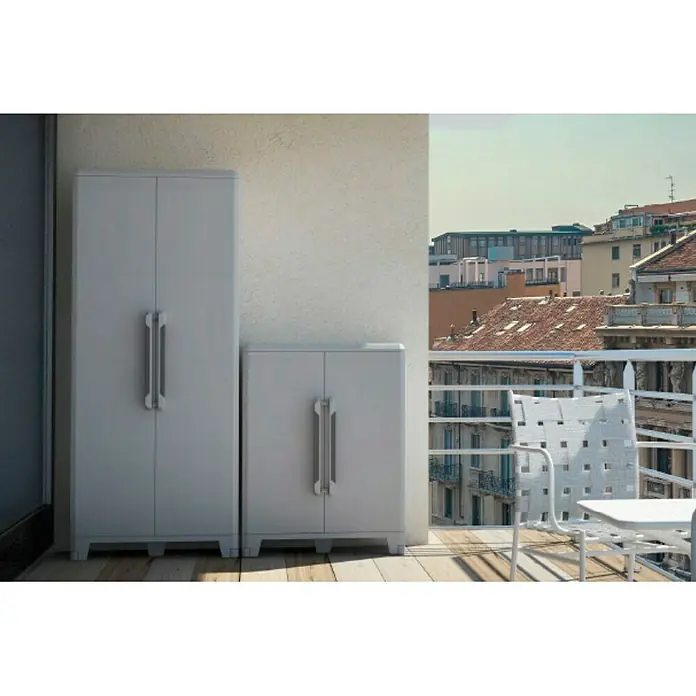 Terry Transforming Armario multiusos de plástico  Modular 5 - L x An x Al: 43,6 x 78 x 225,8 cm - Dos armarios de plástico gris de diferentes tamaños situados en un balcón con vistas a una ciudad. Los armarios tienen tiradores plateados.