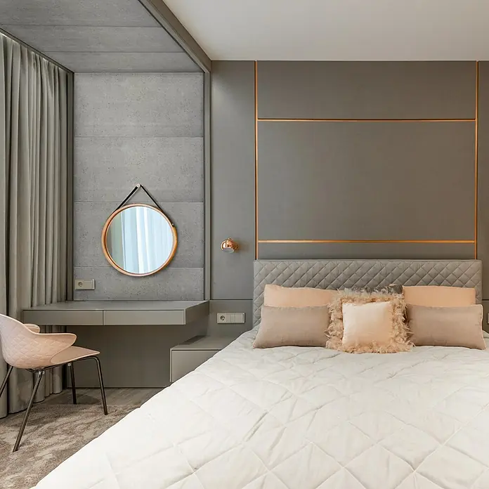 Nmc Decoflair Wandpaneel - Beton Light, 100 x 50 cm, Kunststoff - Ein stilvolles Schlafzimmer mit einem bequemen Bett und einem runden Spiegel, das Design betont Komfort und Eleganz.