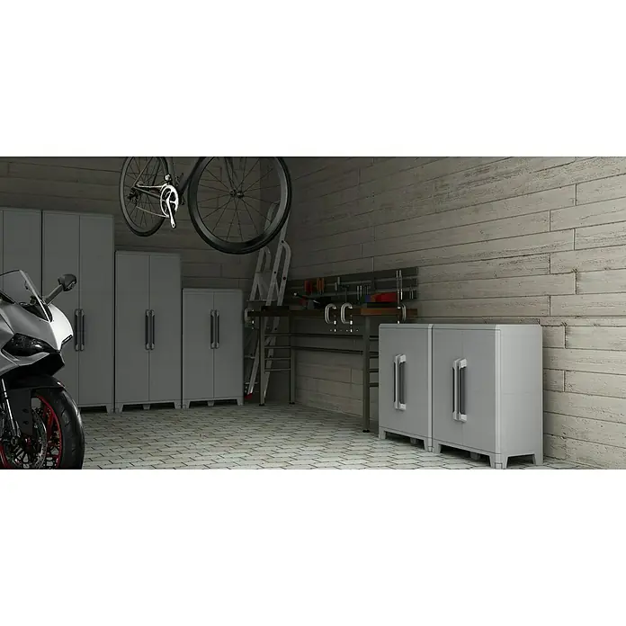 Terry Transforming Armario multiusos de plástico  Modular 4 + Modular 3 - 2 piezas - Interior de garaje con armarios de almacenamiento grises, una moto y una bicicleta suspendida, destacando el espacio organizado y la utilidad.
