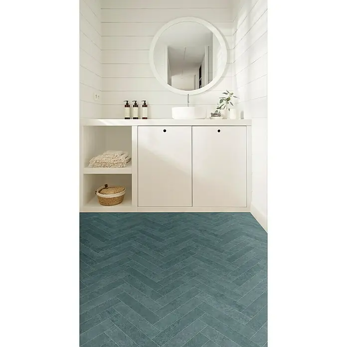 Beauflor PVC-Boden Meterware Calypso - Sonstige, Breite: 400 cm, Dunkelgrau - Badezimmer mit blauem Fischgrätenmuster-Fliesenboden, weißem Waschtisch mit Stauraum und rundem Spiegel.