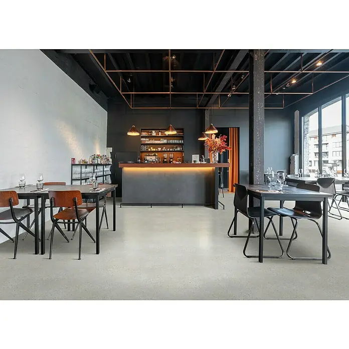 Beauflor PVC-Boden Meterware Themis - Steinoptik, Breite: 400 cm, Anthrazit/Schwarz - Elegantes Restaurant mit schlichten Holztischen und Stühlen vor einer Bar, ideal für stilvolle Gastronomieerlebnisse.