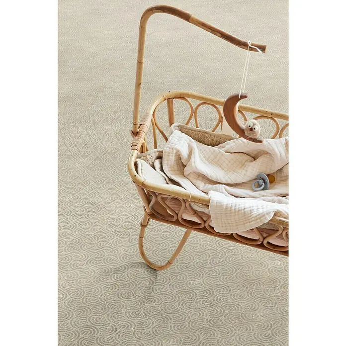 Beauflor PVC-Boden Meterware Calypso - Sonstige, Breite: 400 cm, Beige - Nahaufnahme eines Babykorbs mit Mobile, der auf einem Teppich mit Kreiswirbelmuster steht.