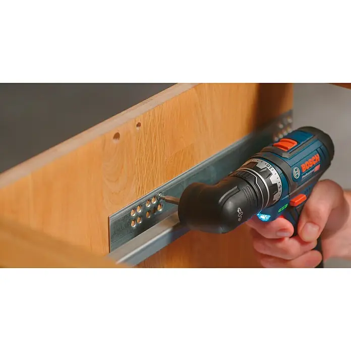 Bosch Professional Winkelaufsatz GFA 12-W - Passend für: Bosch Professional Akku-Bohrschrauber GSR 12V-15 FC - Ein Bosch Professional Akku-Bohrschrauber wird verwendet, um eine Schubladenschiene an einem Holzschrank zu befestigen.