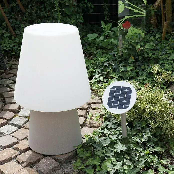 8 Seasons Design No. 1 LED-Solar-Dekoleuchte - Taupe, Weiß, L x B x H: 39 x 39 x 60 cm - Nahaufnahme einer pilzförmigen Gartenleuchte mit Solarmodul, die auf einem gepflasterten Weg inmitten üppigen Grüns steht.