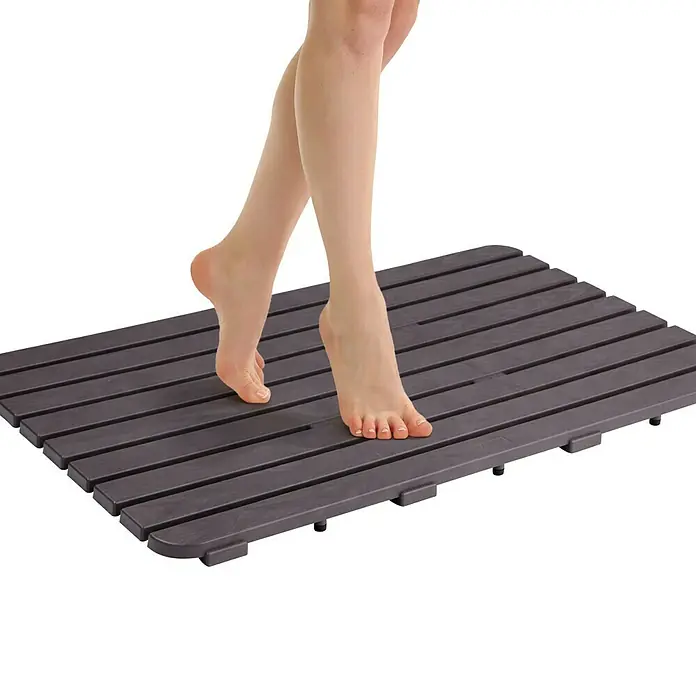 Tatay Tarima de baño - L x An: 50 x 80 cm, Marrón, Polipropileno - Una alfombra de baño gris de listones de madera con pies encima, ideal para baños.