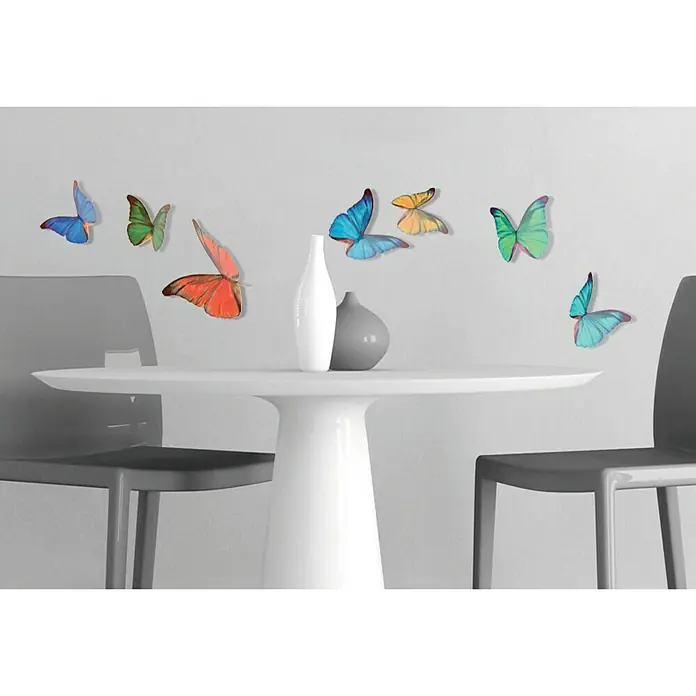 Vinilo de pared 3D Mariposa - Multicolor, Plástico - Decoración de pared con mariposas coloridas que parecen flotar sobre una mesa con jarrones, dando un toque vibrante a cualquier espacio.