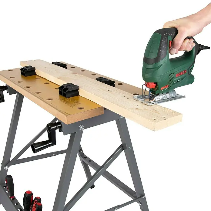 Werkbank Klappbar - L x B: 63,5 x 60,6 cm, Arbeitshöhe: 76 cm, Belastbarkeit: 150 kg - Werkbank mit Holz und Stichsäge. Die Werkbank ist grau und hat eine gelbe Arbeitsfläche mit Löchern und Klemmen zur Befestigung von Werkstücken.