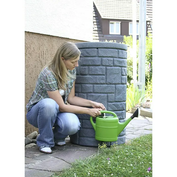 Arves Regenspeicher Arcado - 230 l, Black Granitfarben - Frau befüllt eine grüne Gießkanne an einer grauen Regentonne im Garten. Praktische Wasserversorgung für Pflanzen.