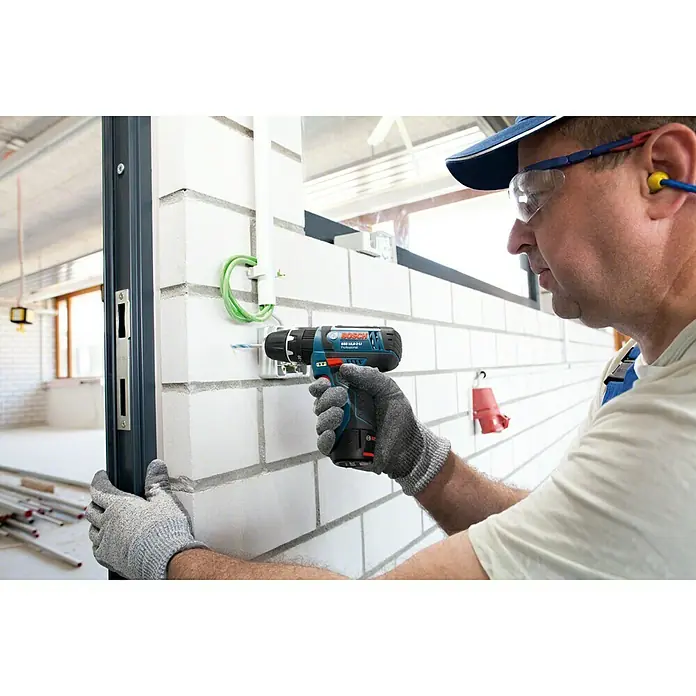 Bosch Professional Akku-Schlagbohrschrauber GSB 12V-15 L-Boxx - 12 V, Ohne Akku, 0 Ah, 30 Nm, Ohne Akku mit Holster - Akkubohrschrauber Bosch GSR 12V-30 Professional bei Montagearbeiten an einer Wand mit einem Handwerker im Hintergrund.