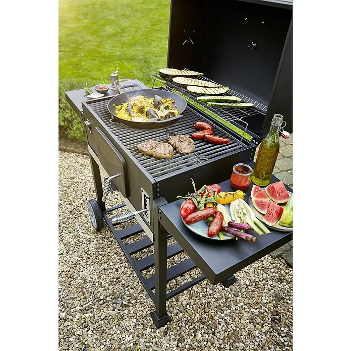 Kingstone KMS Barbacoa de carbón Black Angus XXL - Superficie de la parrilla (An x Pr): 70 x 43 cm, Negro - La parrilla con comida en preparación. Paella, filetes y salchichas chisporrotean en la parrilla para una deliciosa experiencia culinaria al aire libre.
