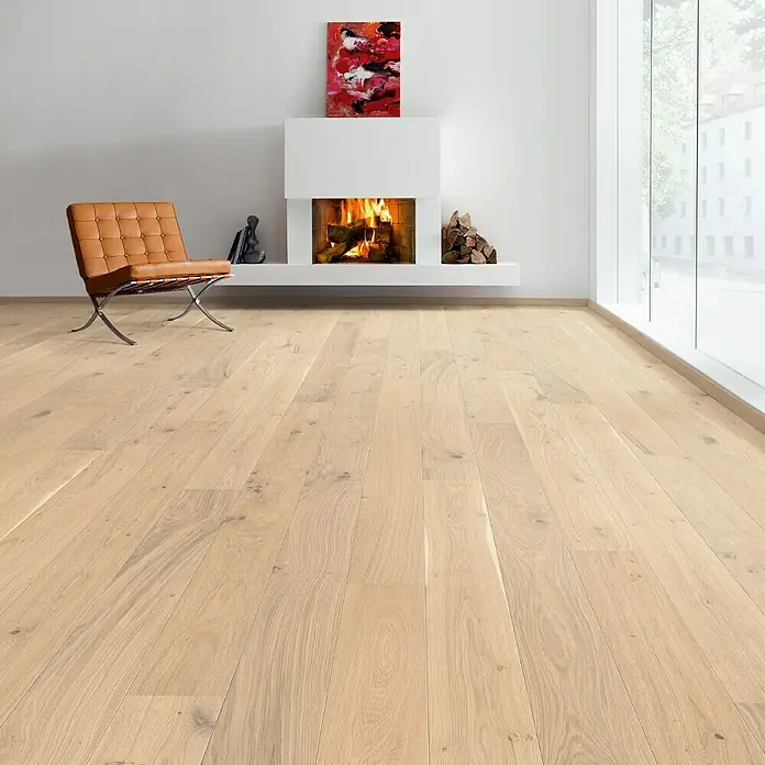 Living by Haro Parkett - Eiche Weiß strukturiert Naturöl, Landhausdiele, 2.200 x 180 x 12 mm - Helles Eichenparkett erhellt einen Raum mit modernem Kamin, Kunst und stilvollem Ledersessel. Das Parkett strahlt Wärme und Eleganz aus.